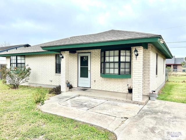 view of front facade featuring a front lawn and a patio area