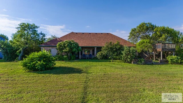 back of house with a lawn and a deck