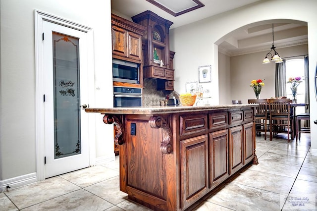 kitchen featuring a center island, stainless steel appliances, tasteful backsplash, and a notable chandelier