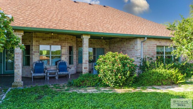 rear view of house featuring a yard and a patio
