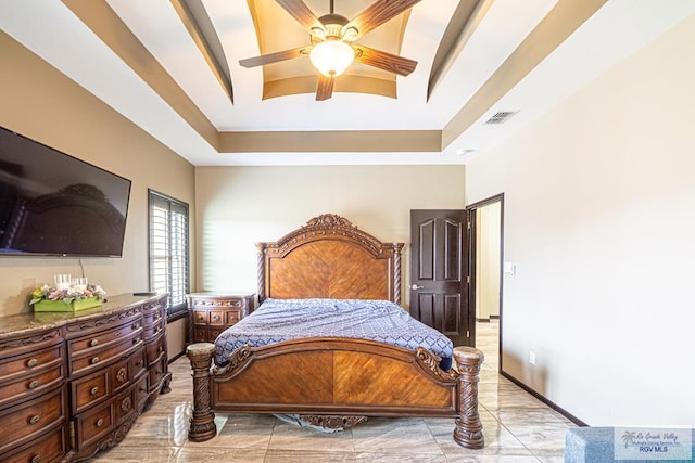 bedroom with ceiling fan, a raised ceiling, and visible vents