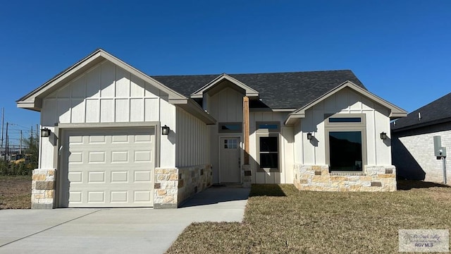 modern farmhouse featuring an attached garage, a shingled roof, concrete driveway, stone siding, and board and batten siding