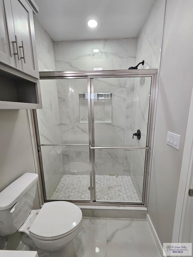 bathroom featuring recessed lighting, toilet, marble finish floor, and a shower stall