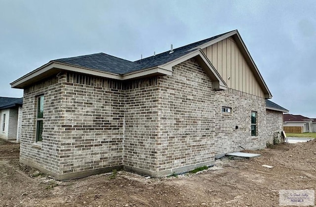 view of side of property with brick siding and board and batten siding