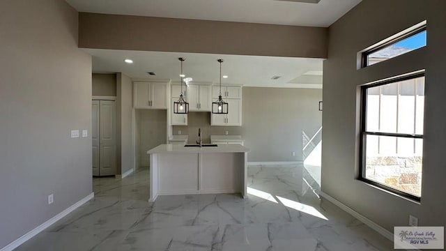 kitchen with baseboards, recessed lighting, a sink, white cabinetry, and marble finish floor