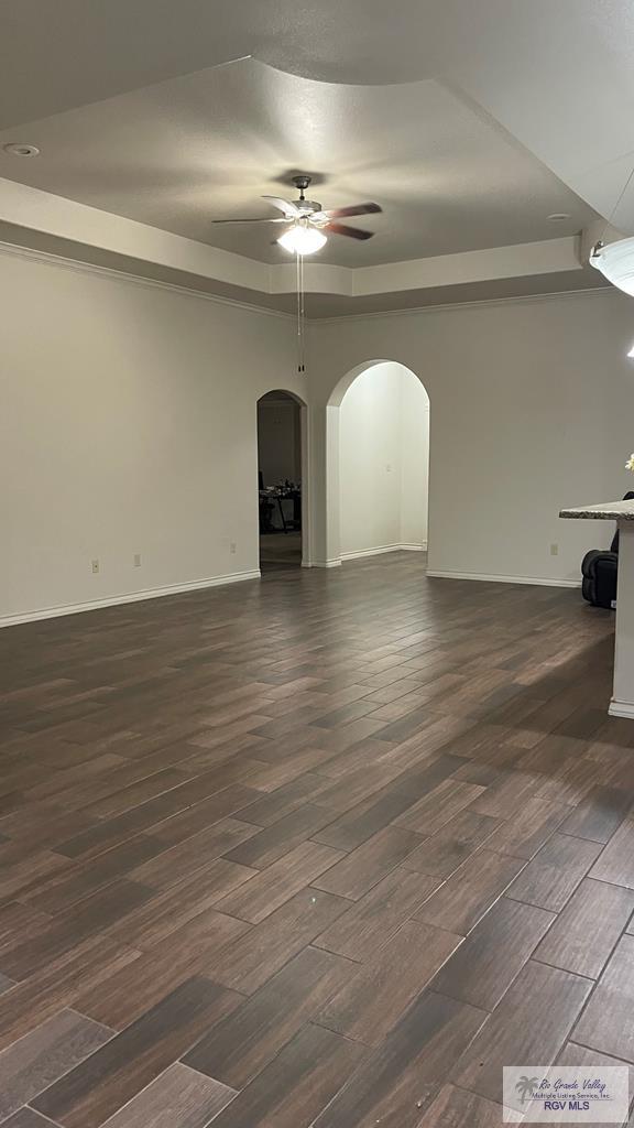 unfurnished living room featuring ceiling fan and dark wood-type flooring