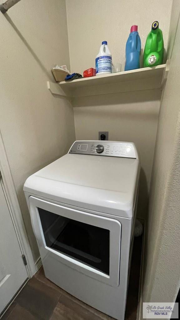 laundry area with dark hardwood / wood-style flooring and washer / dryer