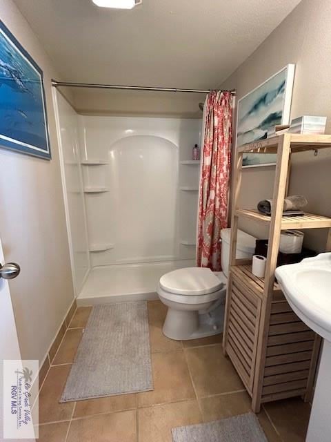 bathroom with tile patterned flooring, toilet, and a shower with shower curtain