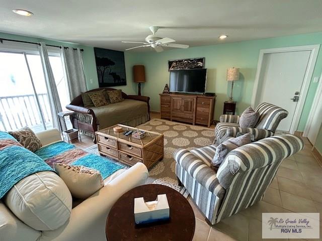 tiled living room featuring a wealth of natural light and ceiling fan