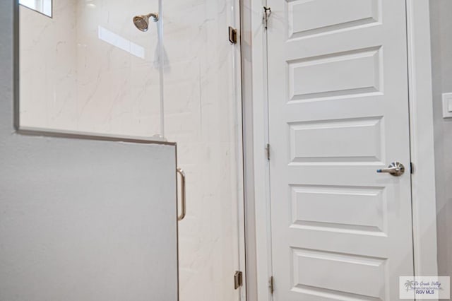 bathroom featuring a marble finish shower