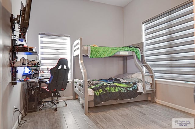 bedroom featuring light wood finished floors and baseboards