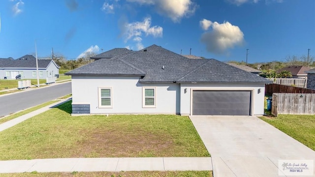 view of front of house with an attached garage, fence, roof with shingles, a residential view, and a front lawn