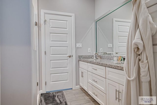 bathroom with wood finished floors and vanity