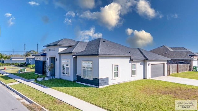 view of front of house with an attached garage, a front lawn, concrete driveway, and stucco siding