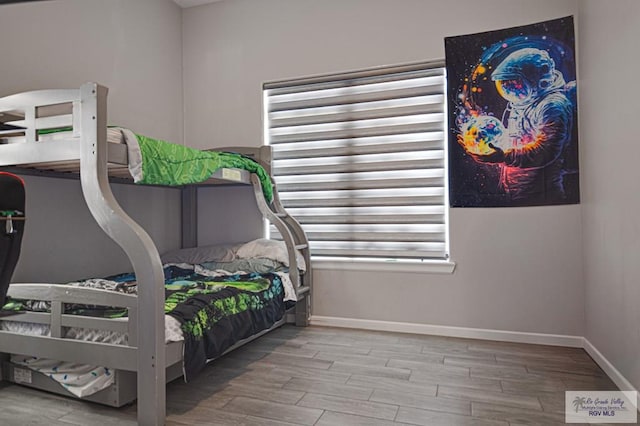 bedroom with baseboards and wood finished floors