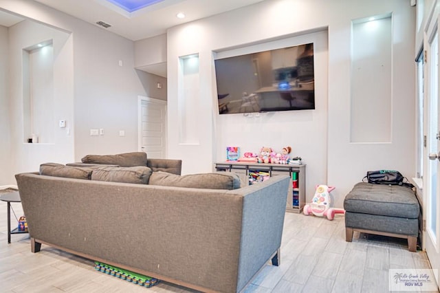 living room with light wood-type flooring, visible vents, and recessed lighting