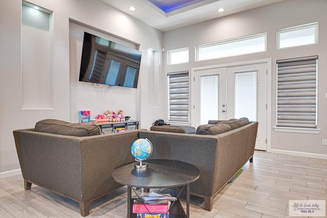 living area with recessed lighting, french doors, light wood-style flooring, and baseboards