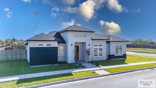 view of front of house featuring a front yard, fence, and stucco siding