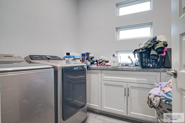 washroom with washer and clothes dryer and cabinet space