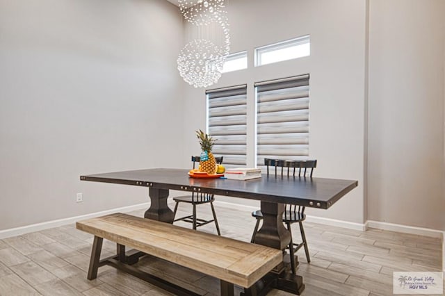 dining room with an inviting chandelier, wood tiled floor, and baseboards