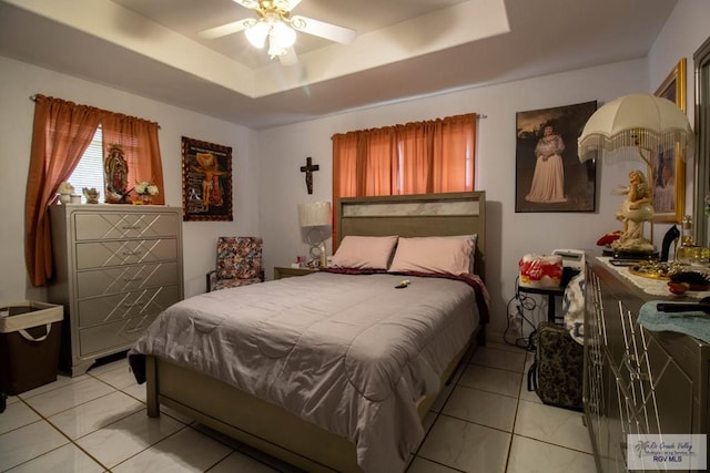 bedroom with ceiling fan and a tray ceiling