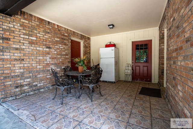 dining area featuring brick wall and stone floors