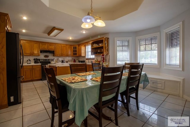 dining space featuring recessed lighting, baseboards, a raised ceiling, and light tile patterned flooring