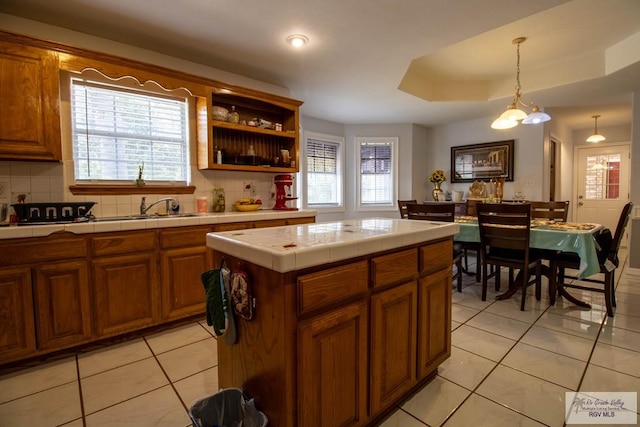 kitchen featuring tile countertops, light tile patterned floors, plenty of natural light, and decorative backsplash