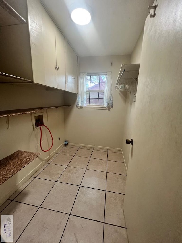 washroom with hookup for a washing machine, light tile patterned flooring, and cabinets