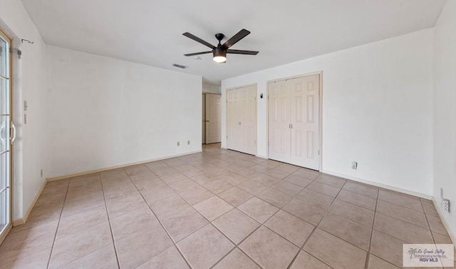 unfurnished bedroom with baseboards, visible vents, and multiple closets