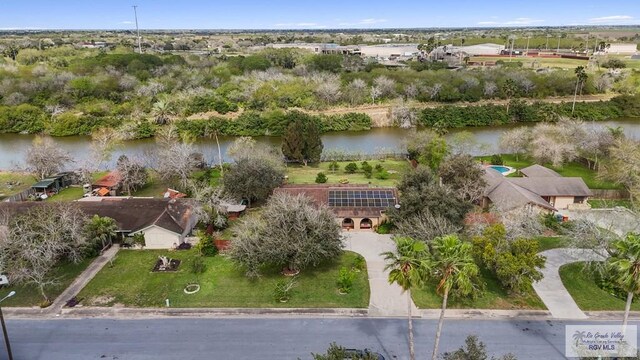 single story home with concrete driveway, solar panels, fence, a front lawn, and brick siding