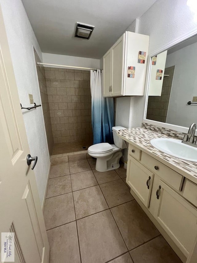 bathroom featuring walk in shower, tile patterned flooring, vanity, and toilet