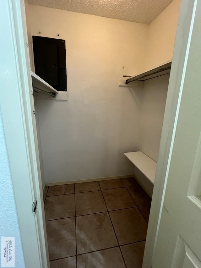 spacious closet with electric panel and tile patterned floors