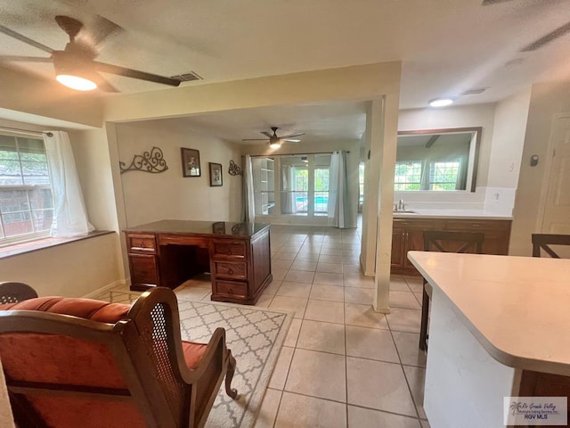 tiled living room with ceiling fan and sink