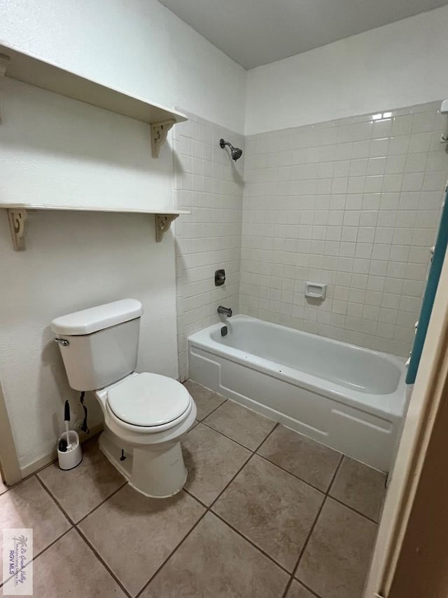 bathroom with tile patterned floors, tiled shower / bath, and toilet