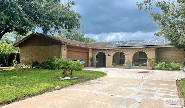 view of front of house featuring solar panels, a garage, and a front yard