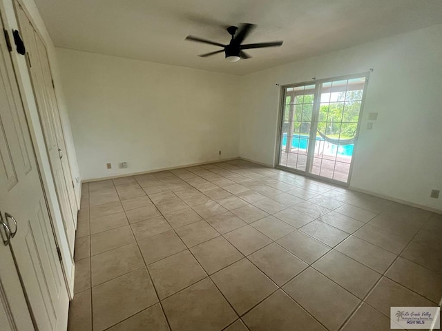 tiled empty room featuring ceiling fan