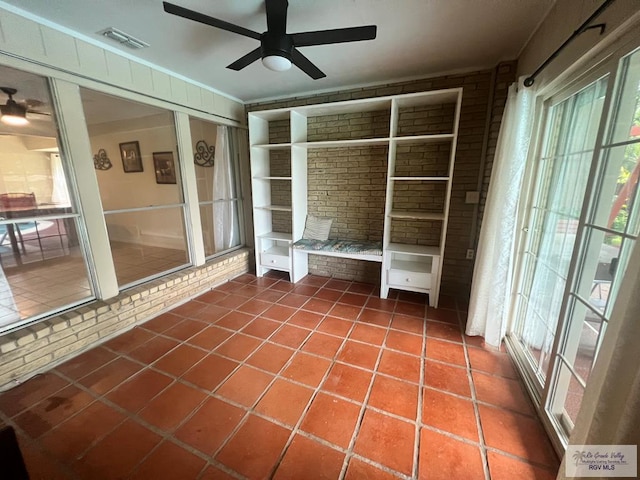 interior space featuring dark tile patterned flooring, ceiling fan, and a wealth of natural light