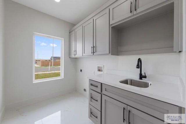 laundry room with washer hookup, electric dryer hookup, cabinets, and sink