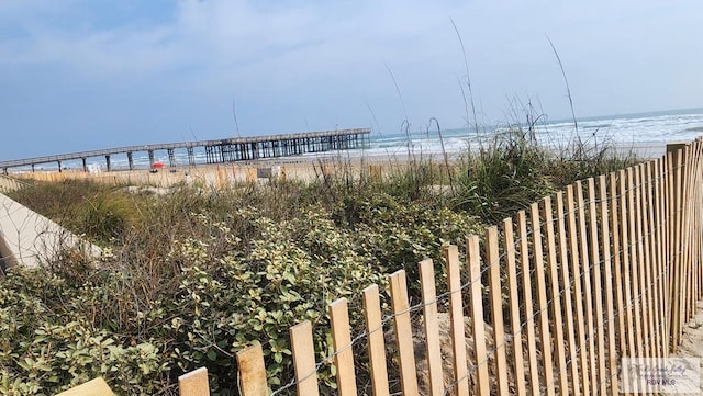 water view with fence and a beach view