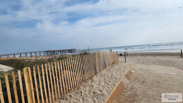 property view of water with a beach view and fence