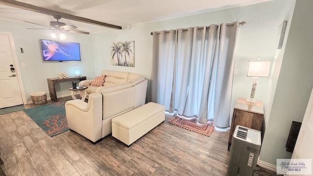 living area with beamed ceiling, wood finished floors, and a ceiling fan