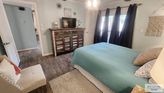 bedroom featuring crown molding, baseboards, and wood finished floors