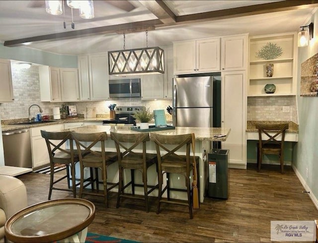 kitchen with a sink, appliances with stainless steel finishes, dark wood-style flooring, and beam ceiling