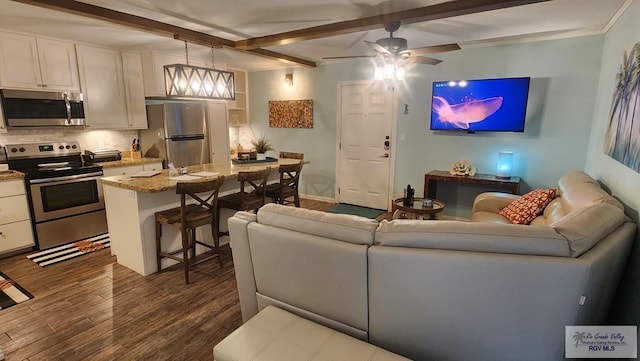 living area with a ceiling fan, baseboards, dark wood finished floors, and beamed ceiling