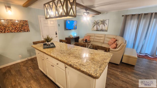 kitchen featuring ceiling fan, dark wood-style flooring, white cabinets, baseboards, and beam ceiling