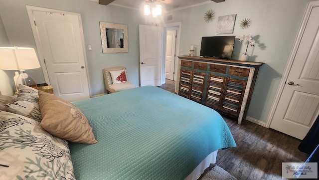 bedroom with baseboards, visible vents, ornamental molding, and wood finished floors