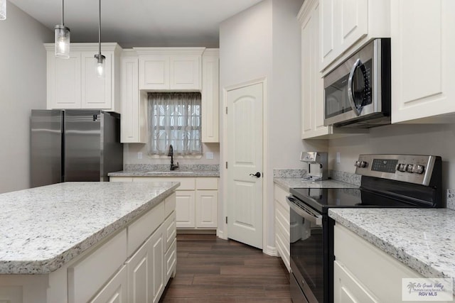 kitchen with white cabinetry, sink, dark wood-type flooring, pendant lighting, and appliances with stainless steel finishes