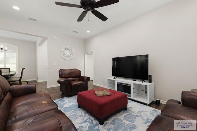 living room with hardwood / wood-style floors and ceiling fan with notable chandelier