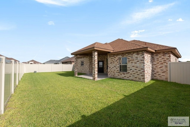 rear view of property featuring a patio area and a yard